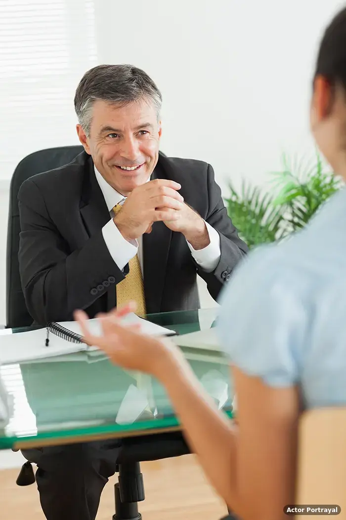 Attorney reviewing lemon law case details with a client across the desk (Actor Portrayal)