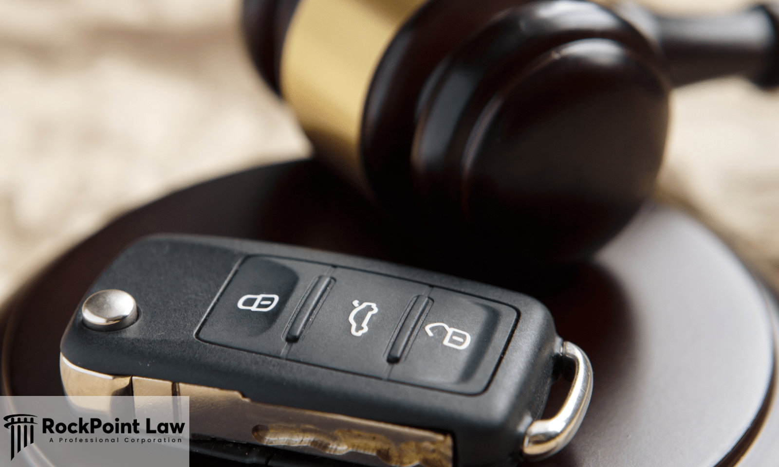 Car key fob beside a judge's gavel representing Lemon Law claims and vehicle buyback rights