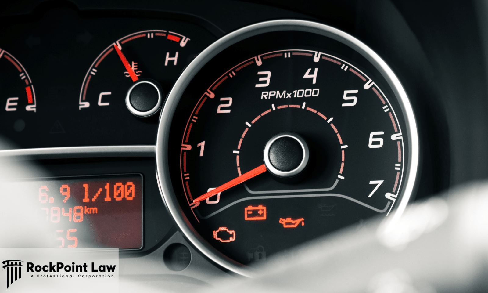 Close-up of a vehicle dashboard displaying the check engine light, battery warning, oil pressure warning, and other instrument panel indicators.