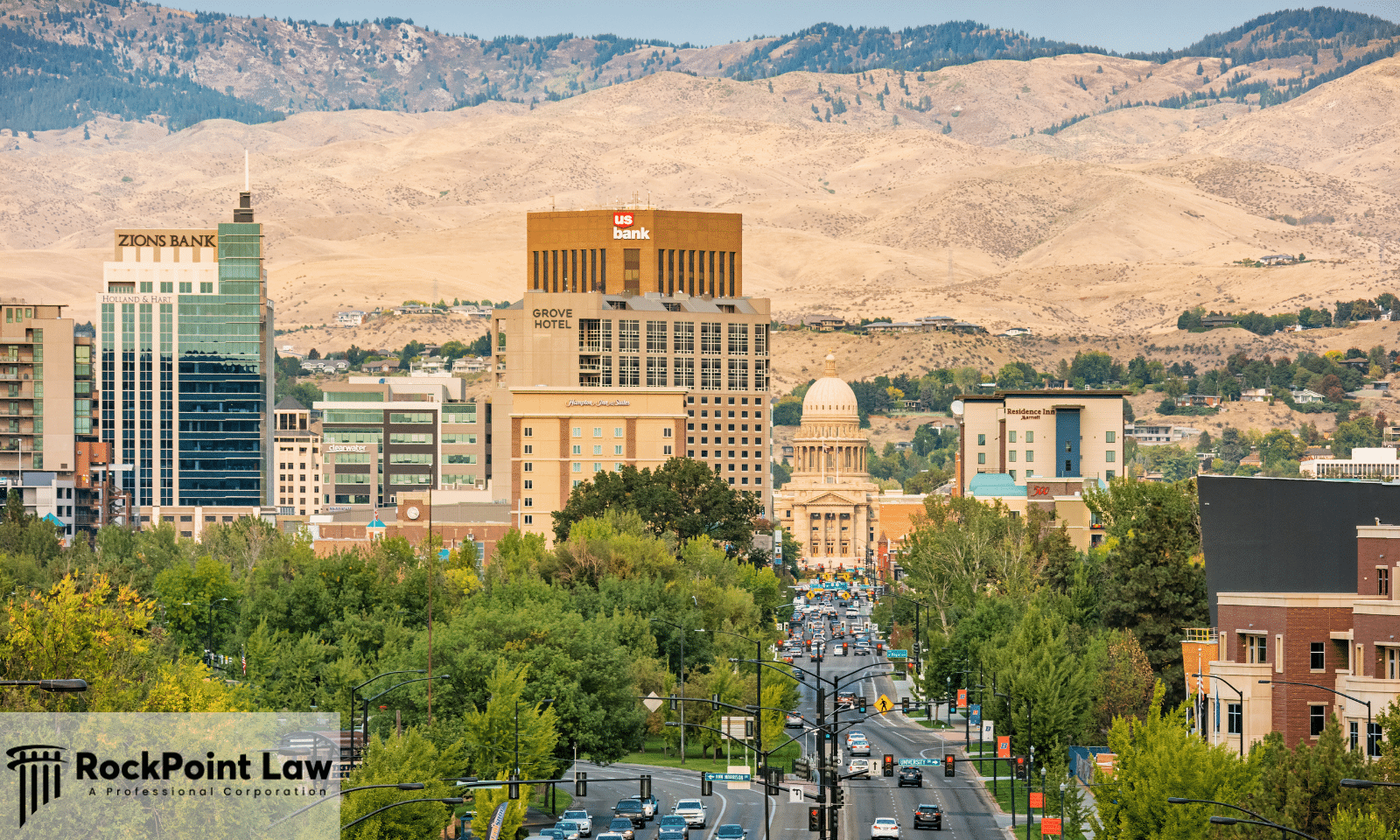 Panoramic view of downtown Boise, Idaho, featuring the Idaho State Capitol, city skyline, and surrounding foothills on a clear day.