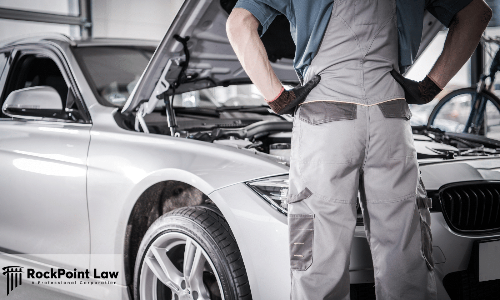 Automotive technician standing in front of a vehicle with the hood open during a recall inspection