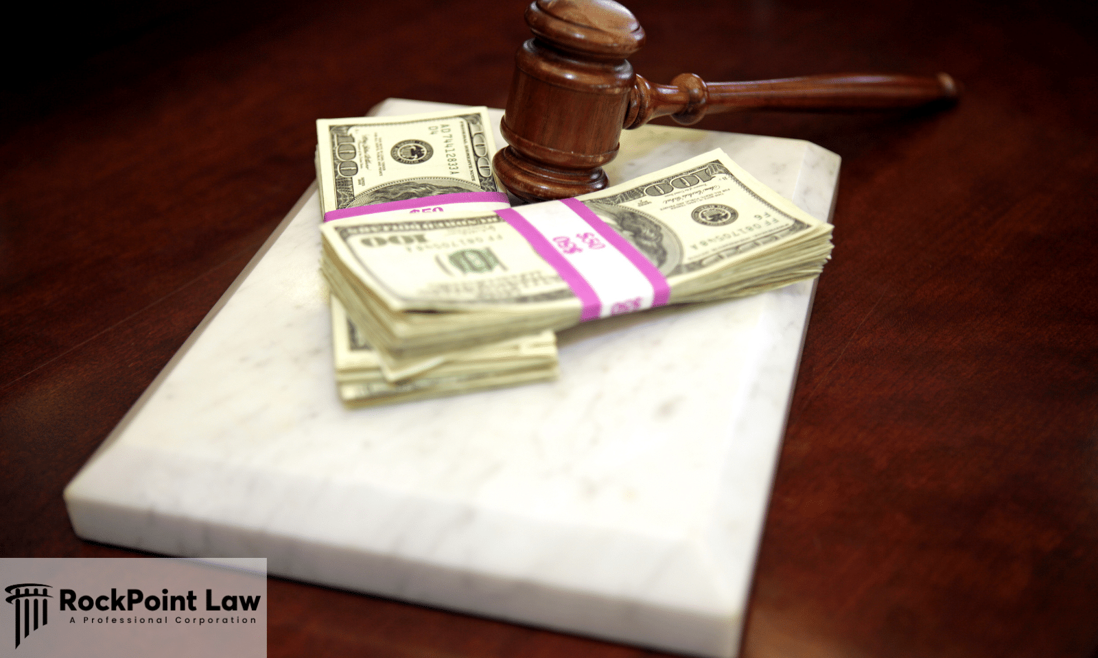 Judge's gavel resting beside banded stacks of hundred-dollar bills on a desk.