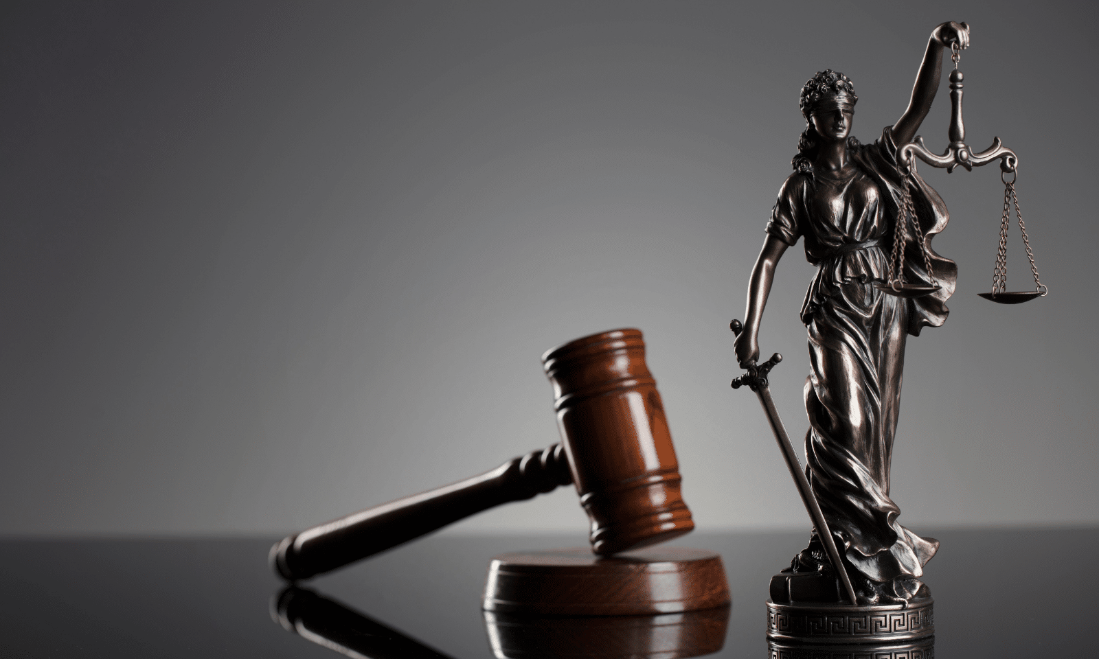Lady Justice statue and a judge's gavel representing legal rights and consumer protection under Lemon Laws.