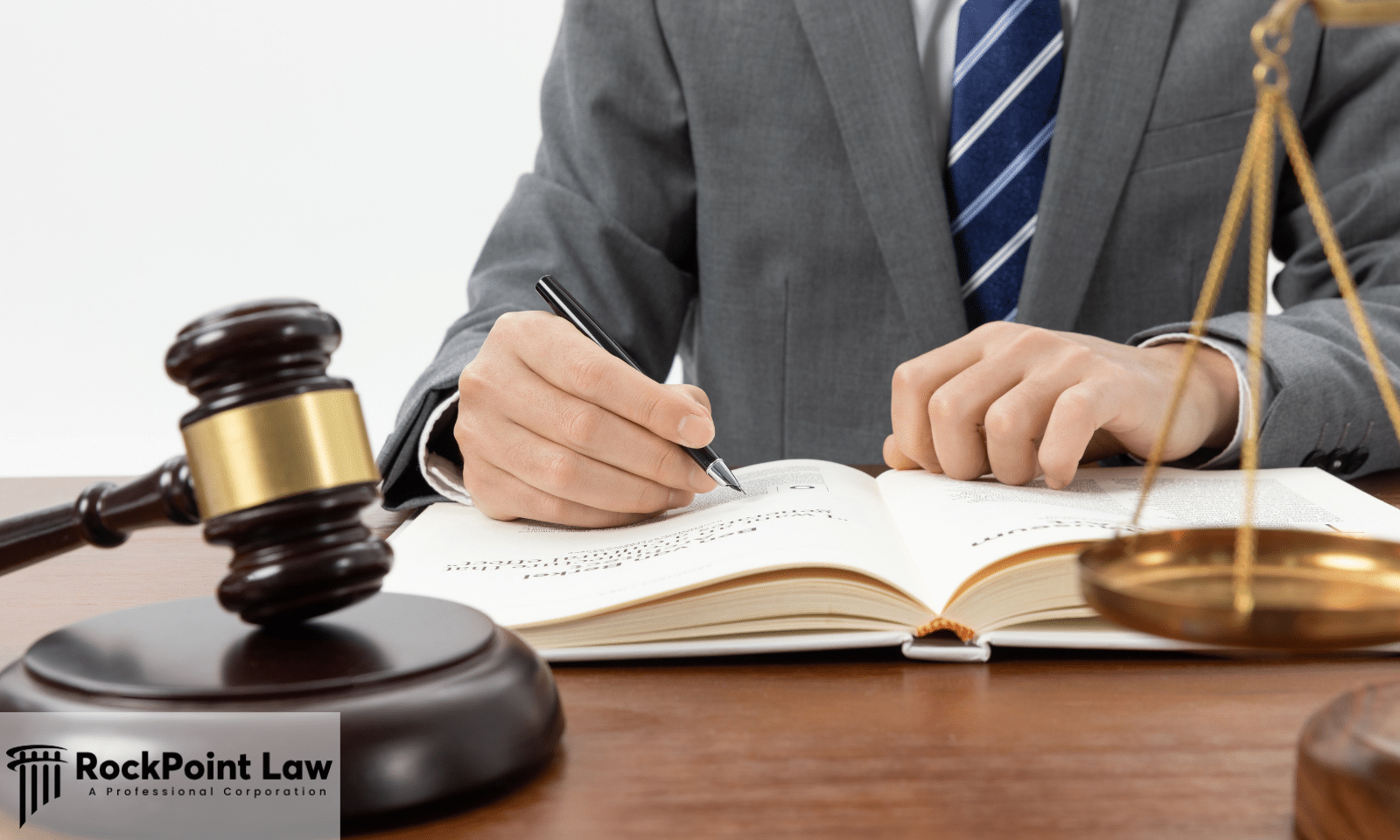 Attorney reviewing legal documents beside a judge's gavel and scales of justice while preparing a Lemon Law claim.