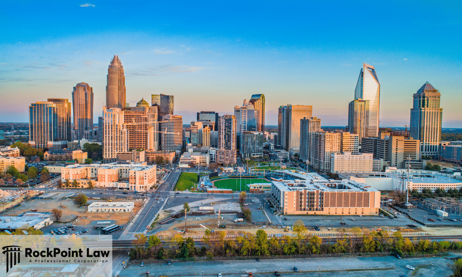 Aerial view of the Charlotte, North Carolina skyline at sunset, illustrating a guide to North Carolina lemon law.