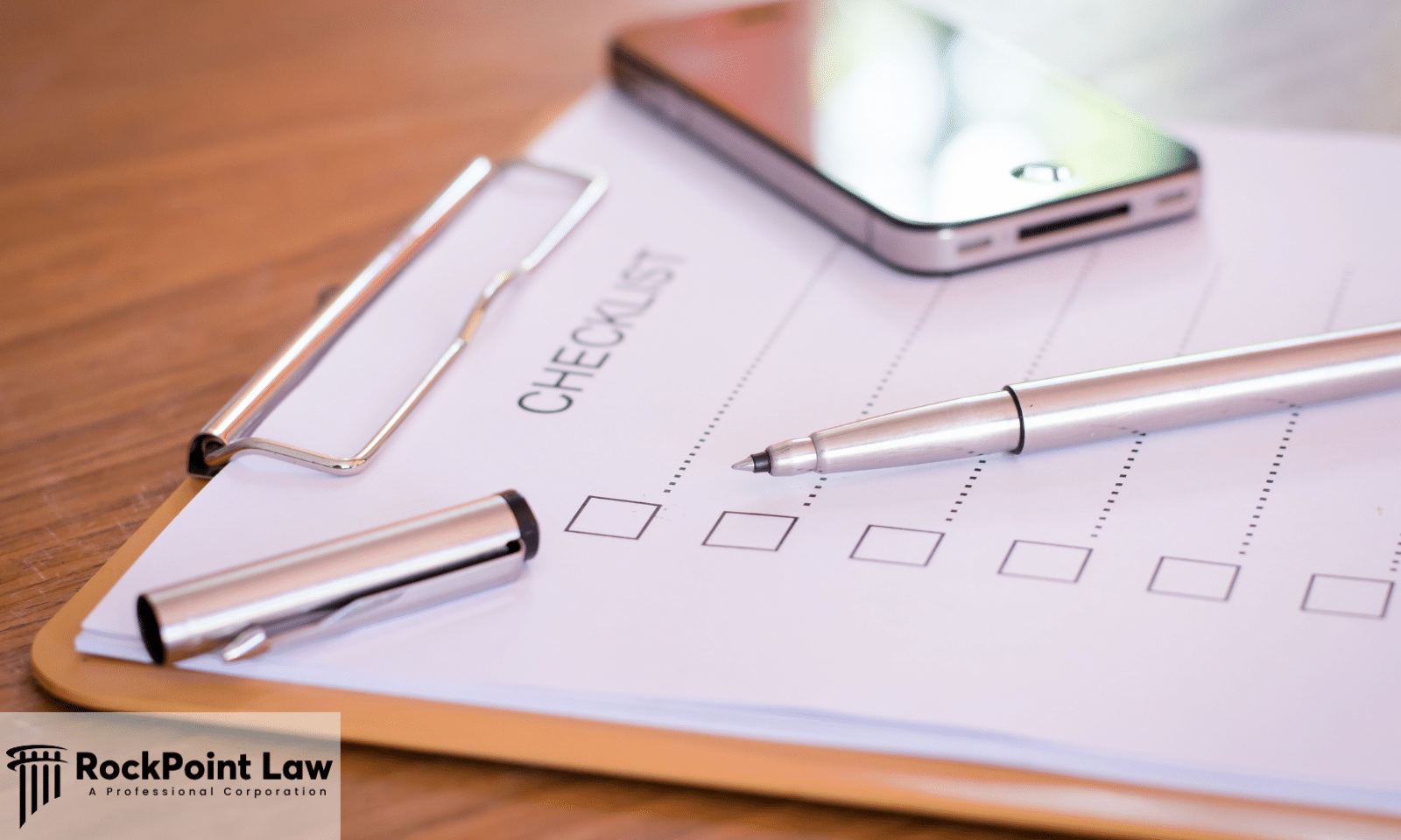 Lemon Law claim checklist with pen and smartphone, featuring RockPoint Law branding.