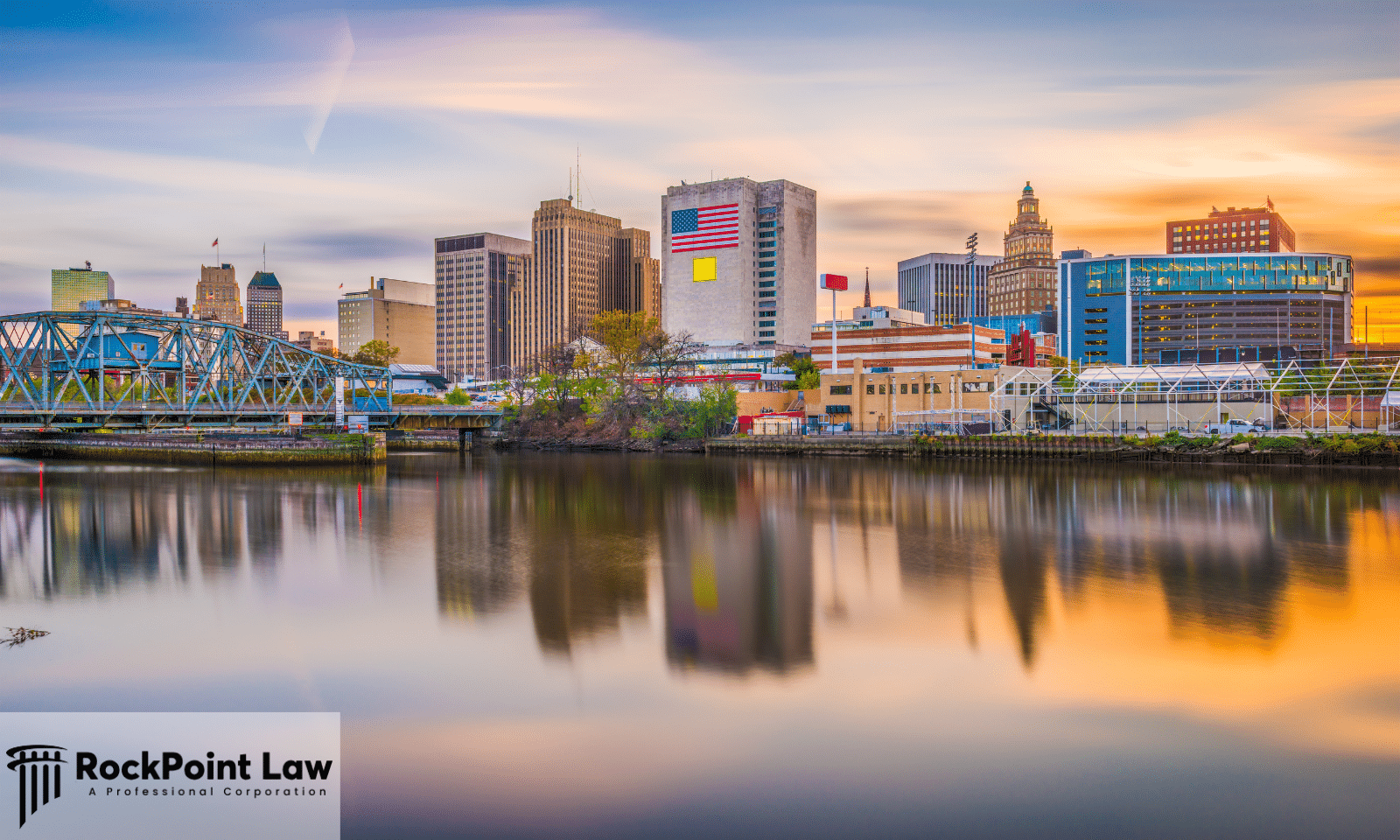 Newark, New Jersey skyline at sunset reflected in the Passaic River, with RockPoint Law branding.