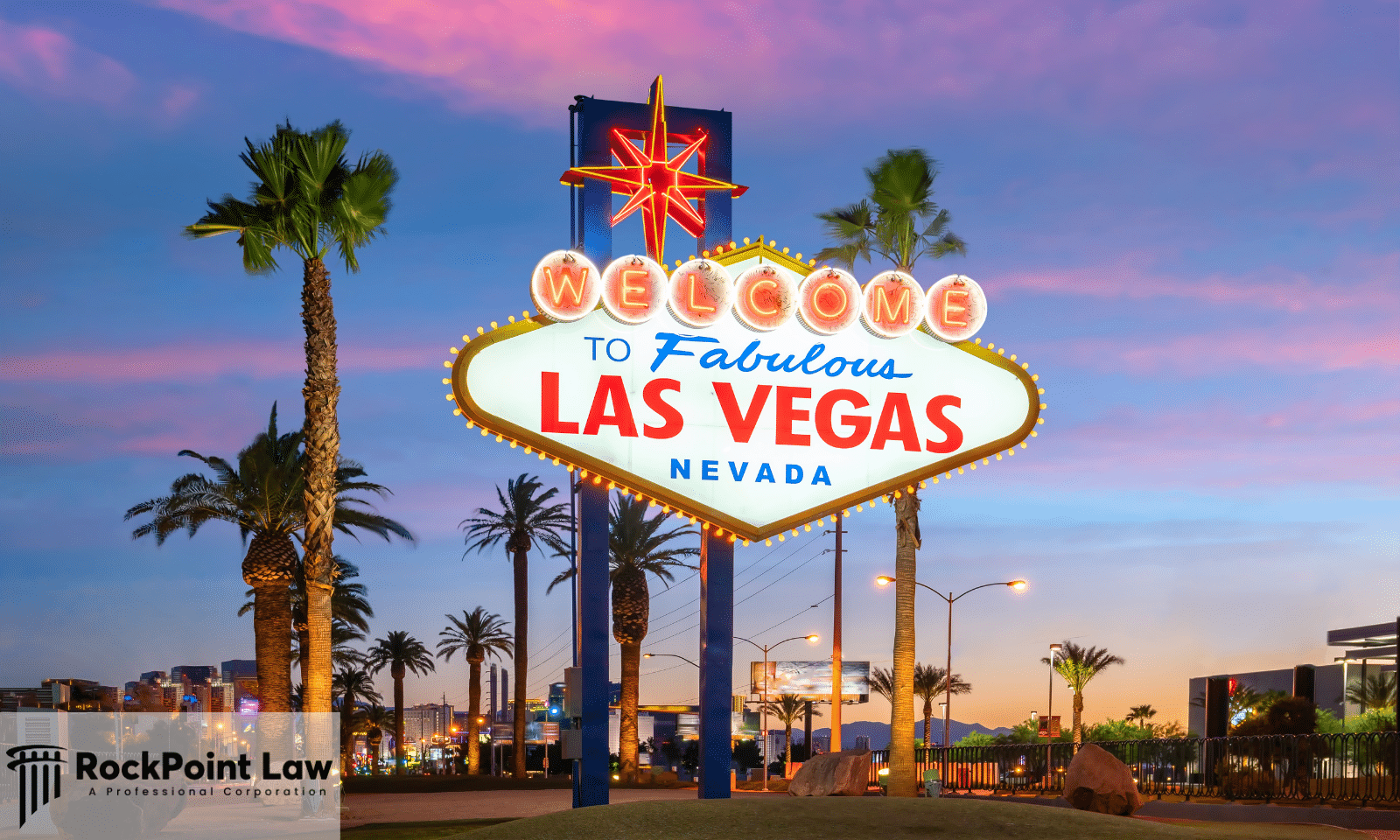 The Welcome to Fabulous Las Vegas, Nevada sign illuminated at dusk with palm trees and the Las Vegas Strip behind it.