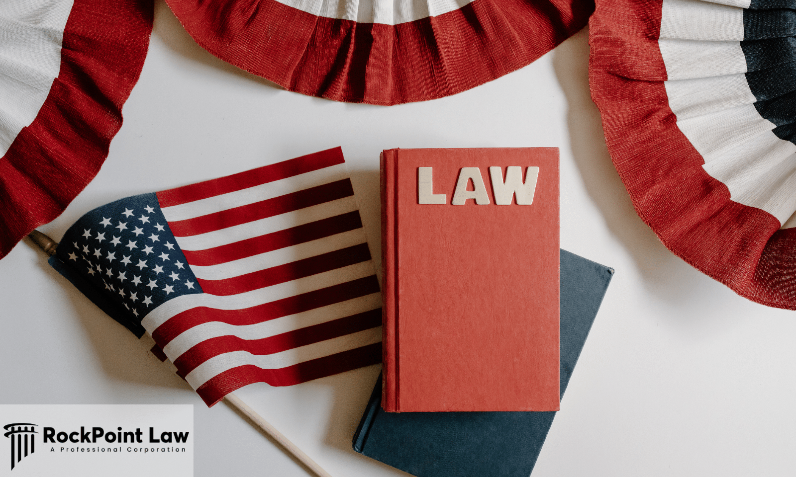 A book marked LAW beside a small United States flag and patriotic bunting, representing consumer rights under Oklahoma lemon law.