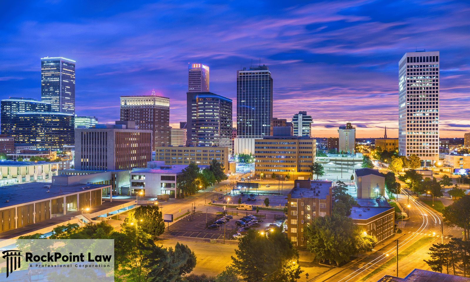 The Tulsa, Oklahoma skyline lit up at dusk under a purple sky, illustrating a guide to Oklahoma lemon law.