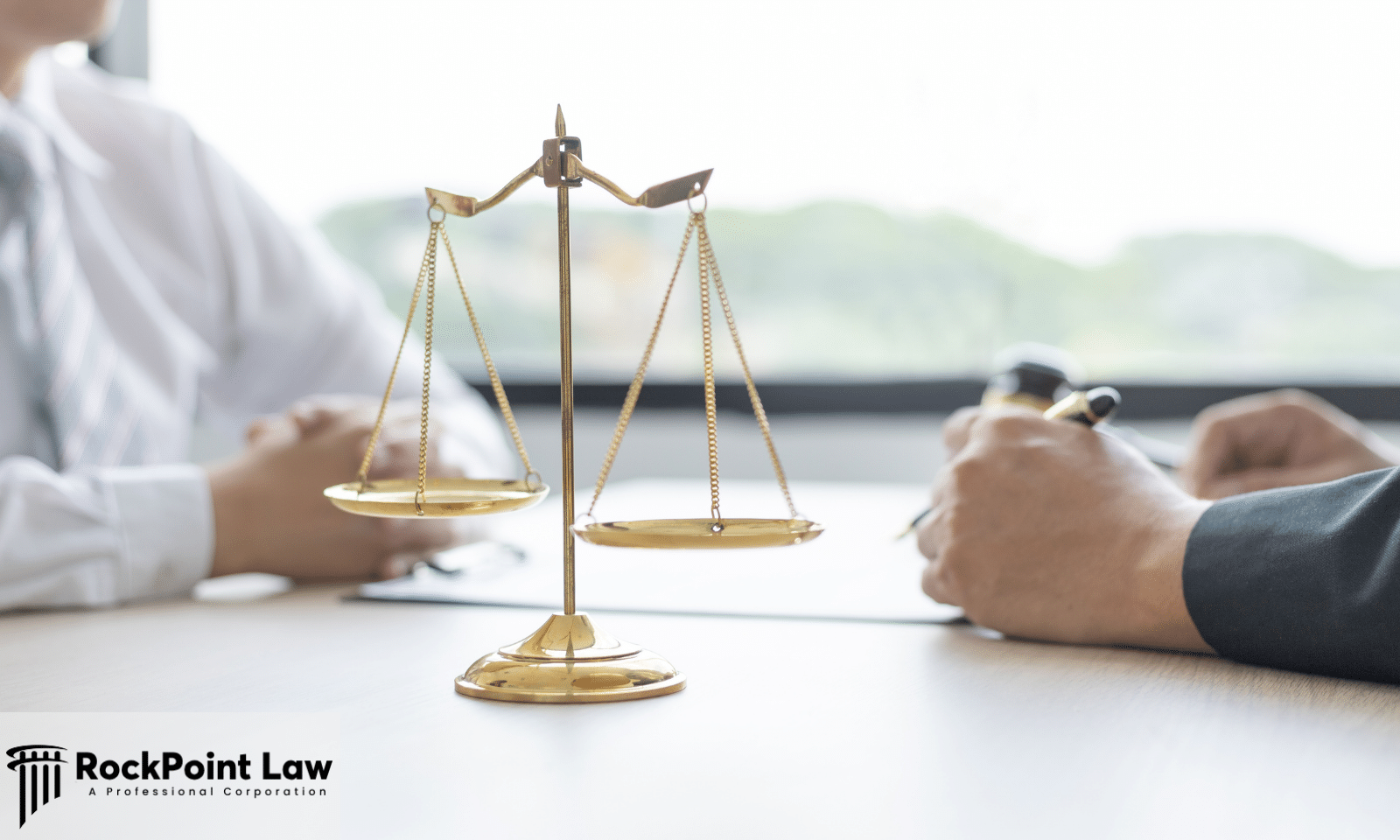 Scales of justice on a desk between an attorney and a client, representing the records needed for a Utah lemon law claim