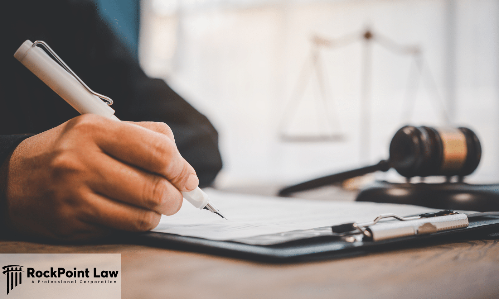 Person completing Vermont lemon law claim paperwork beside a gavel and scales of justice