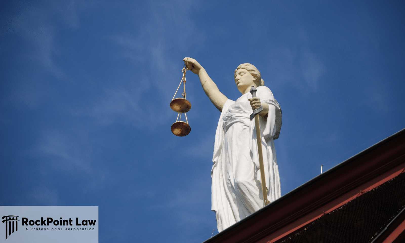 Statue of Lady Justice holding scales above a courthouse roof, representing how West Virginia Lemon Law disputes are decided.